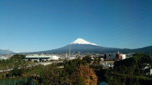新幹線車窓から五合目付近まで雪を被った富士山を遠望